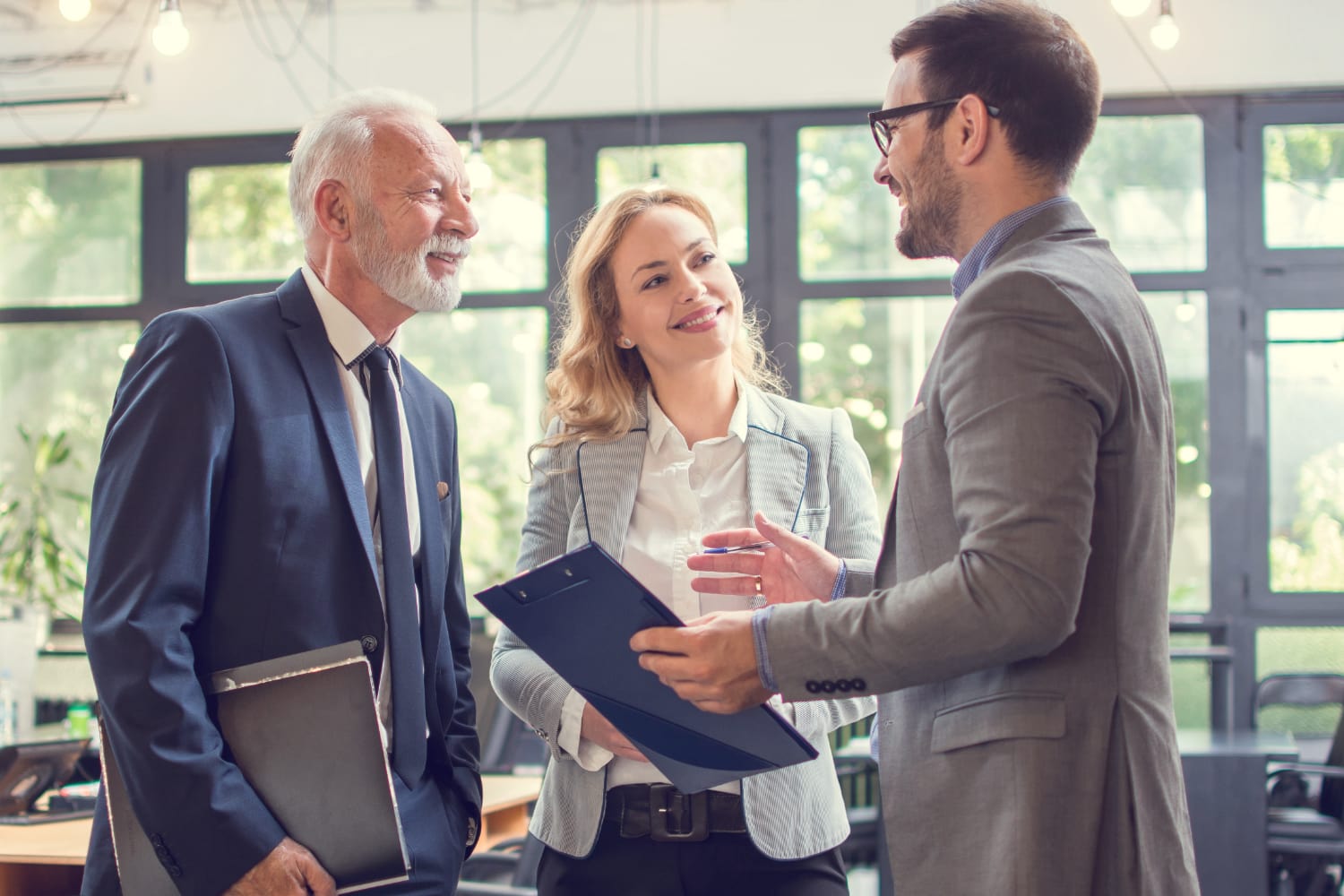 three financial advisors talking together in an office